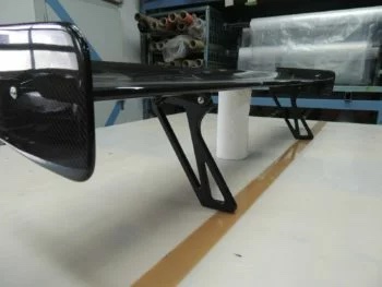 Detailansicht der Spoilerhalterungen aus Metall am Carbonflügel BMW F22