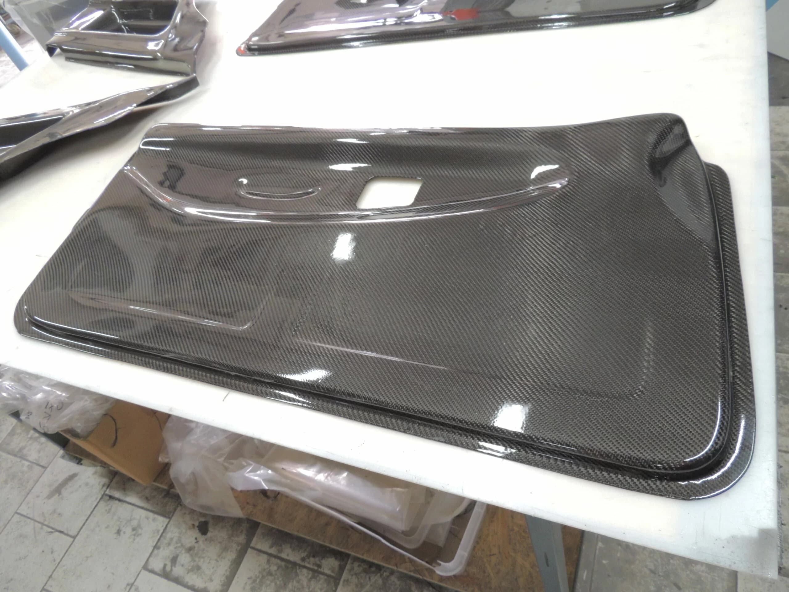 Carbon Türverkleidung BMW E36 Coupé mit Griffausschnitt, fertig laminiert auf Arbeitstisch