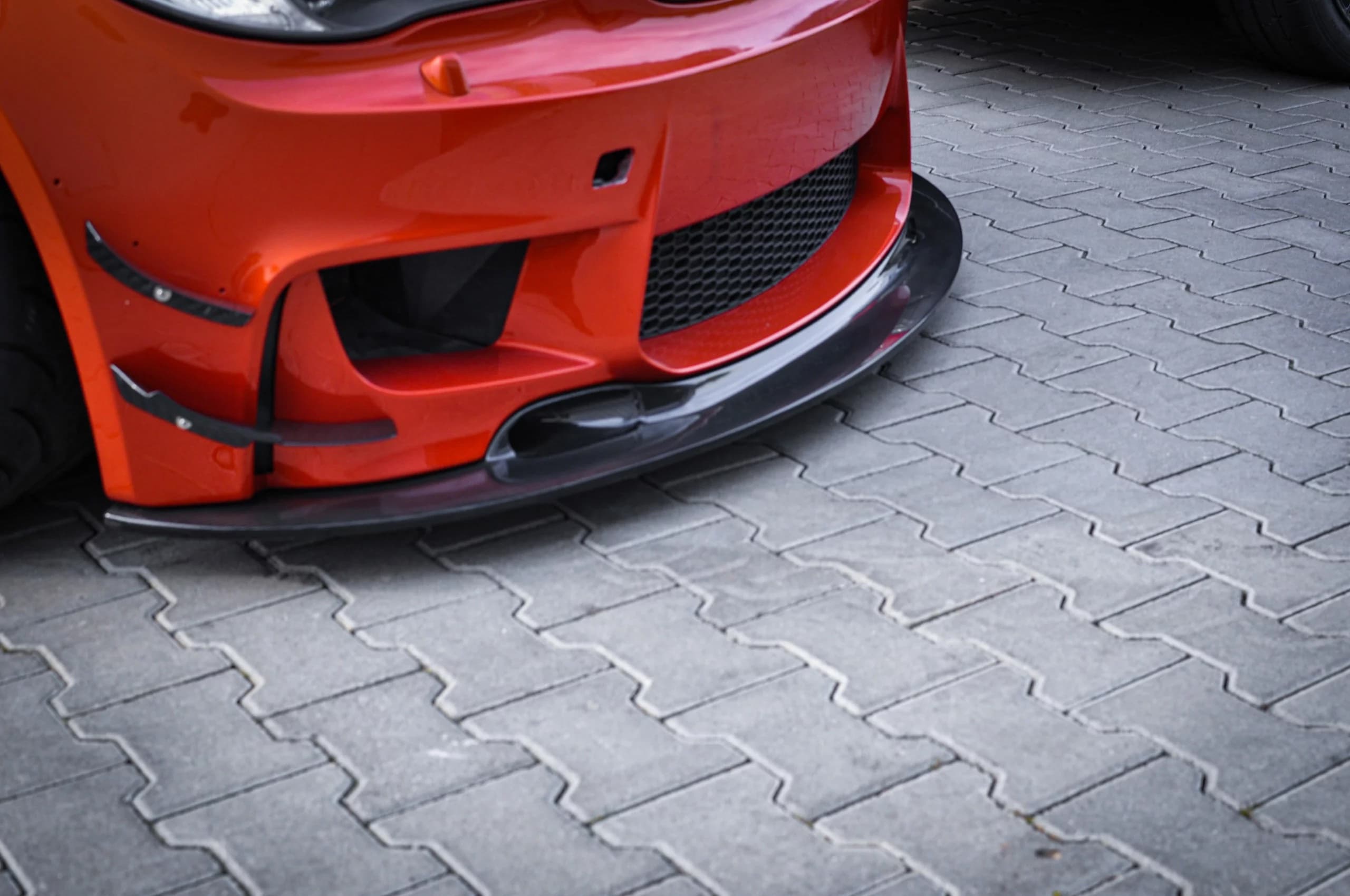 Seitliche Detailaufnahme der Sichtcarbon-Frontlippe am BMW 1er M E82