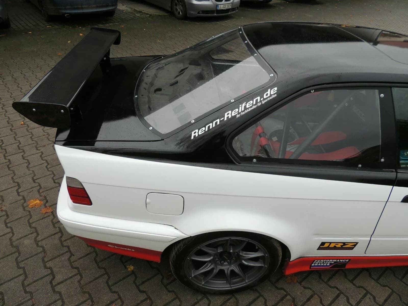 Seitliche Ansicht BMW E36 mit montiertem Carbon-Heckflügel und Polycarbonat-Heckscheibe