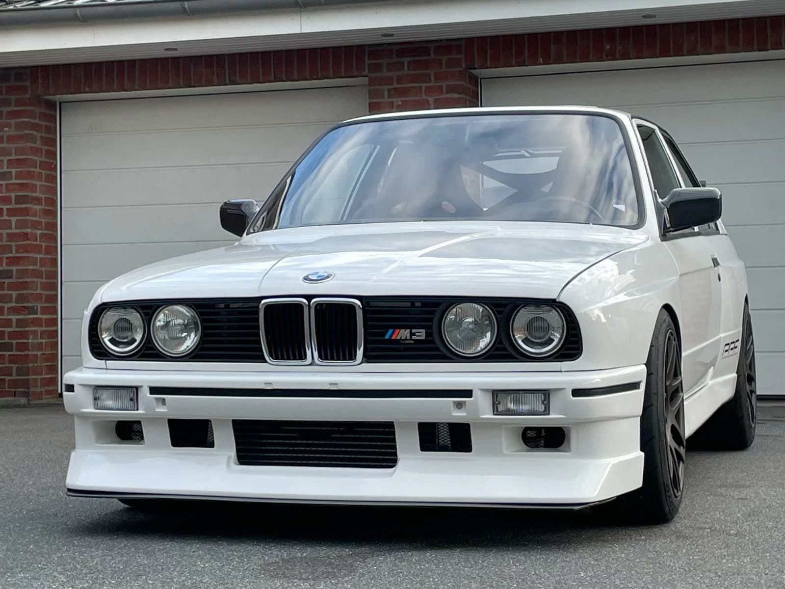 BMW E30 M3 mit Carbon-Kotflügeln – Frontansicht mit breiter Motorsport-Frontschürze