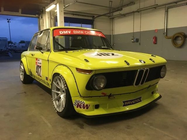 Gelber BMW E10 1502-2002 in der Garage mit Nahaufnahme auf das BMW Verbreiterungskit aus Carbon