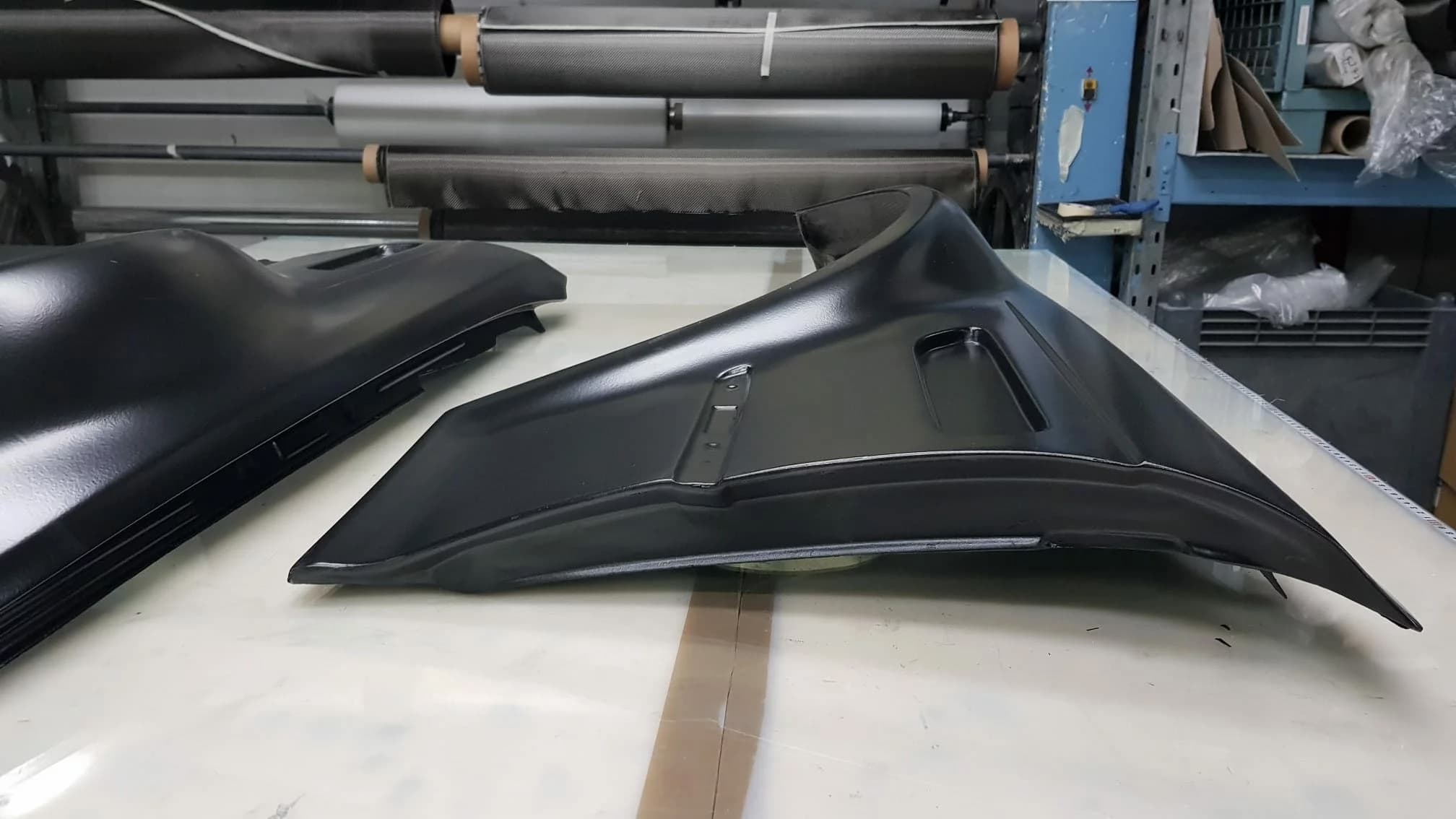 Schwarzer Carbon-Kotflügel für BMW E46 M3, Seitenansicht auf Werkbank, matte Oberfläche