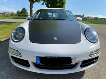 Sichtcarbon Fronthaube Porsche 911 (997), montiert auf weißem Fahrzeug in Frontansicht