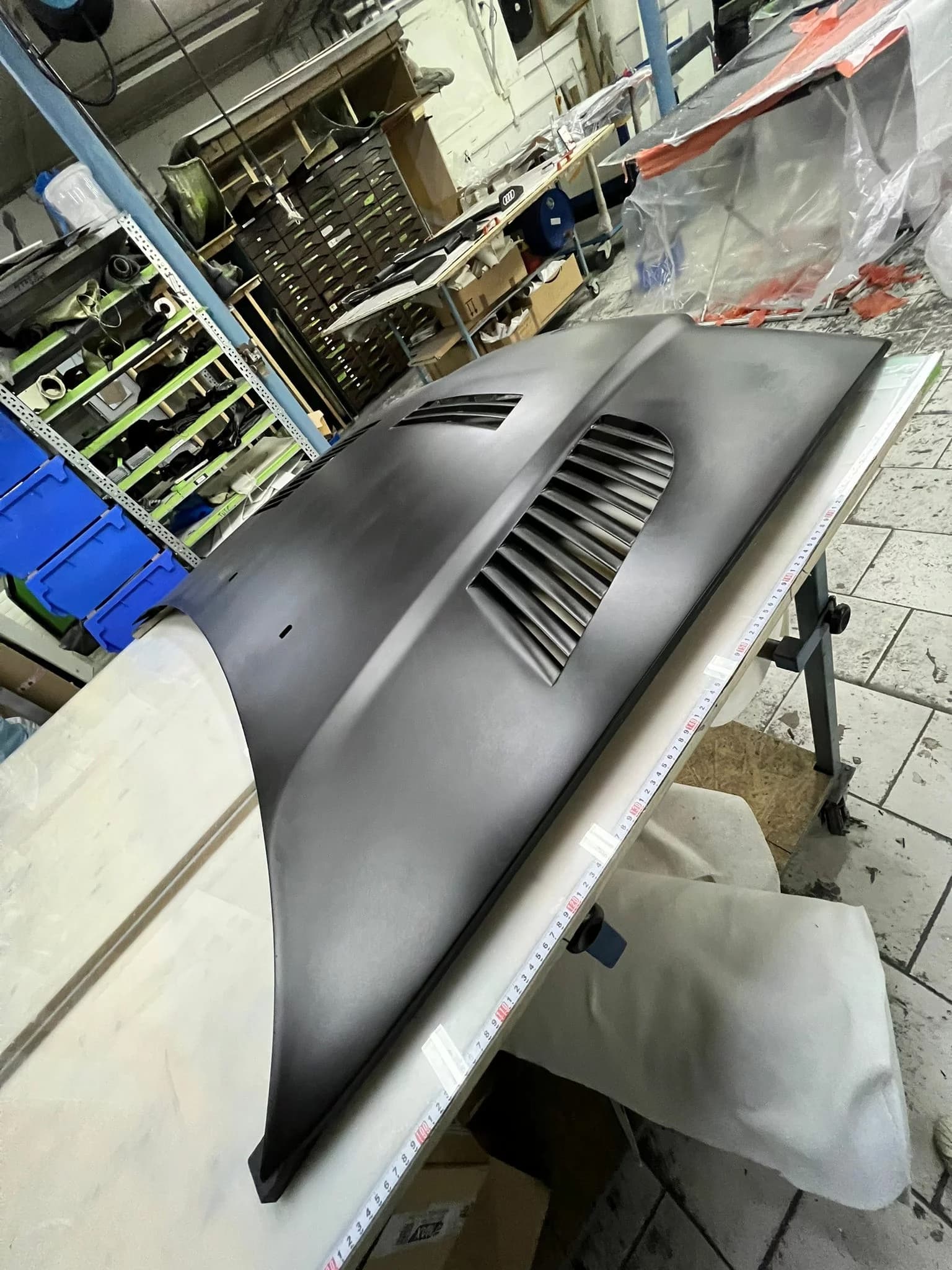 Schwarze GTR-Motorhaube mit integrierten Luftauslässen auf Werkbank