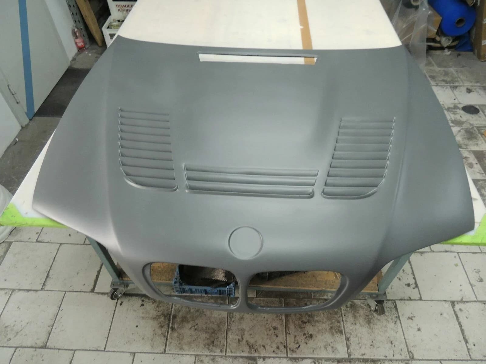 Carbon Motorhaube BMW E46 M3 GTR in grauer Grundierung, Frontansicht mit Lüftungsschlitzen und Mittelöffnung