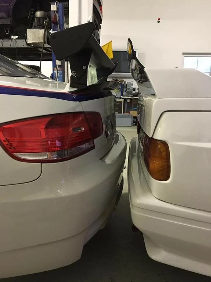 Vergleichsaufnahme zweier Fahrzeuge: Heckflügel des BMW E30 im Abstand zum danebenstehenden Auto.