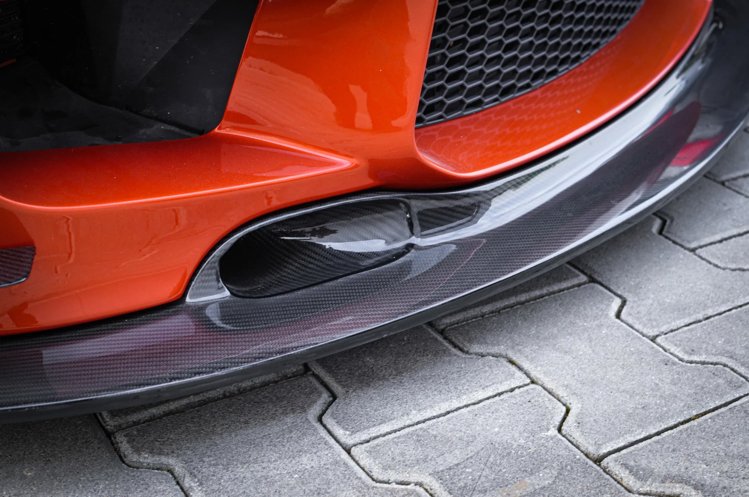 Detailansicht der Sichtcarbon-Frontlippe am BMW E82 1er M mit Luftführung