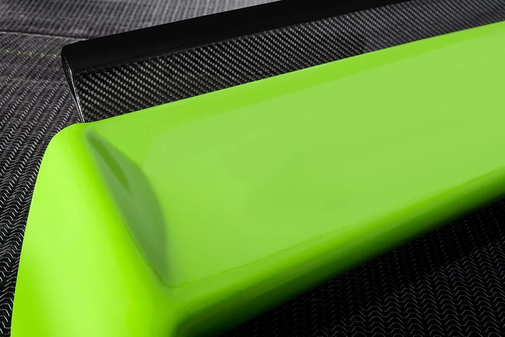 Nahaufnahme der grünen Spoiler-Seitenfläche mit Carbon-Flügelkante im Hintergrund.