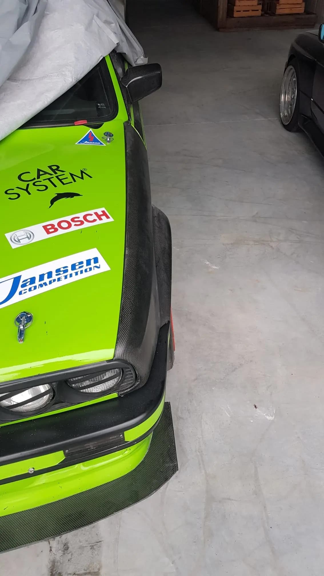 Breiter Carbon-Kotflügel BMW E30, montiert am Fahrzeug mit Motorsport-Lackierung und Schnellverschlüssen