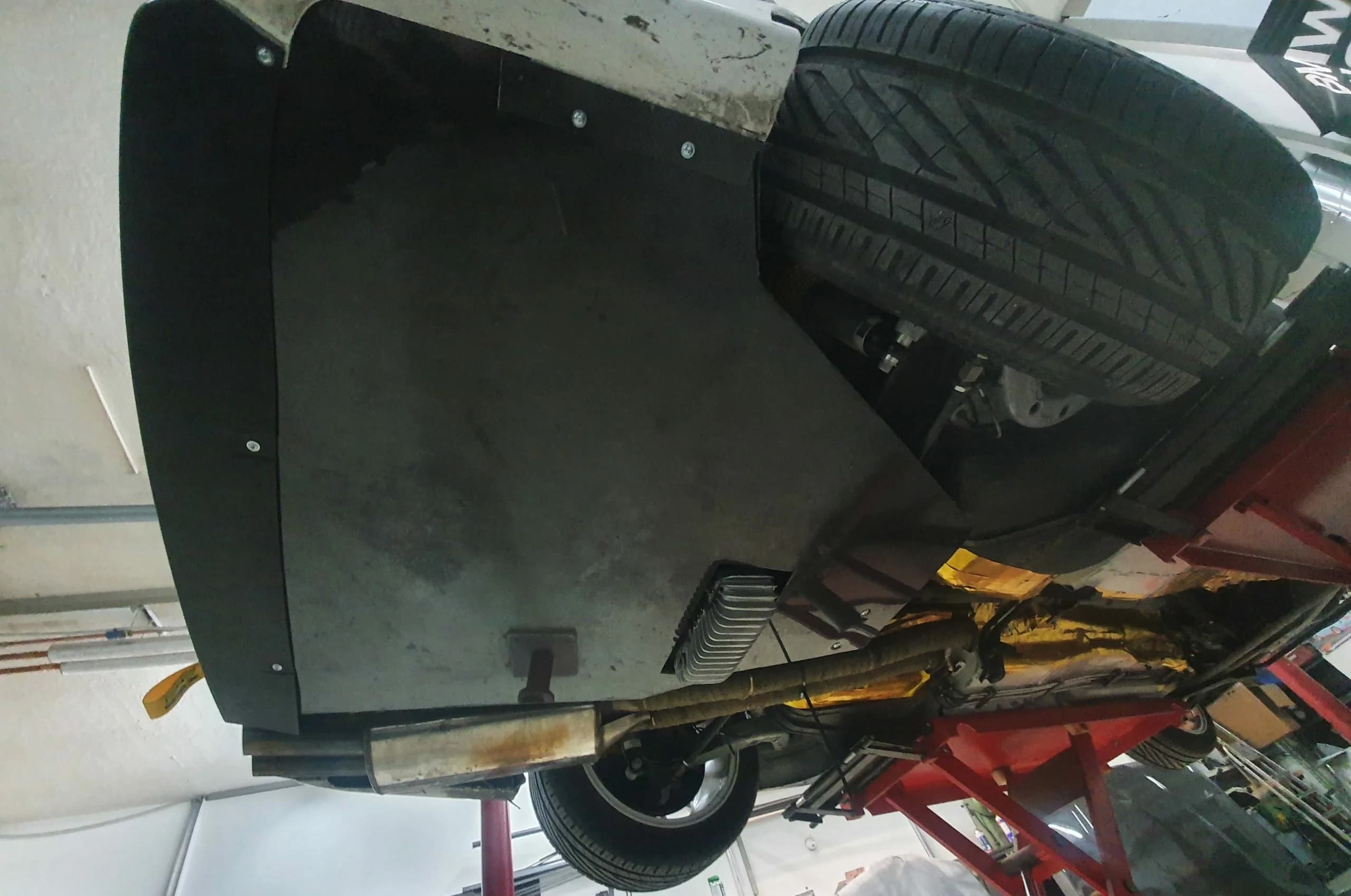 Unterbodenansicht BMW E36 mit montierter Carbon Unterbodenplatte und Auspuffführung