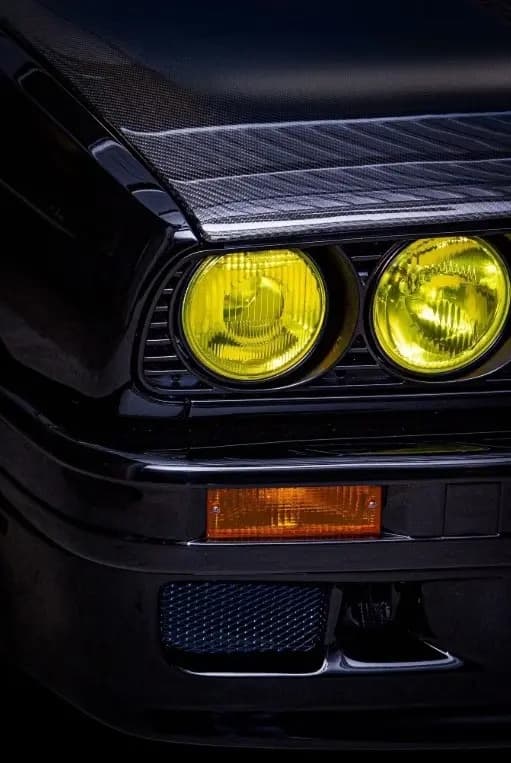 Detail Frontscheinwerfer BMW E30 mit sichtbarer Carbon Motorhaube