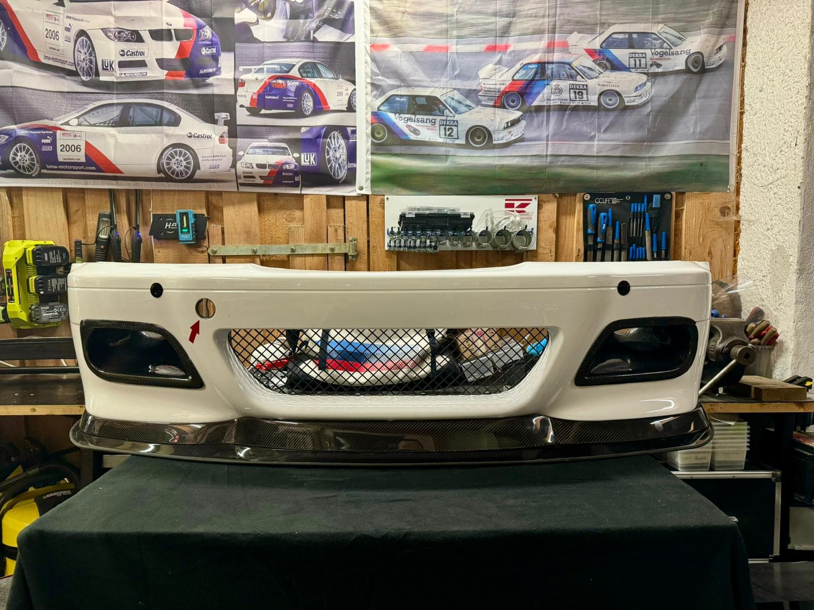 BMW E46 M3 CSL Frontstoßstange mit montiertem Carbon Frontsplitter in Werkstattumgebung.