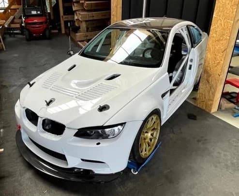 BMW E92 M3 mit montierter Carbon-Motorhaube, geschlossen, Frontansicht in der Werkstatt
