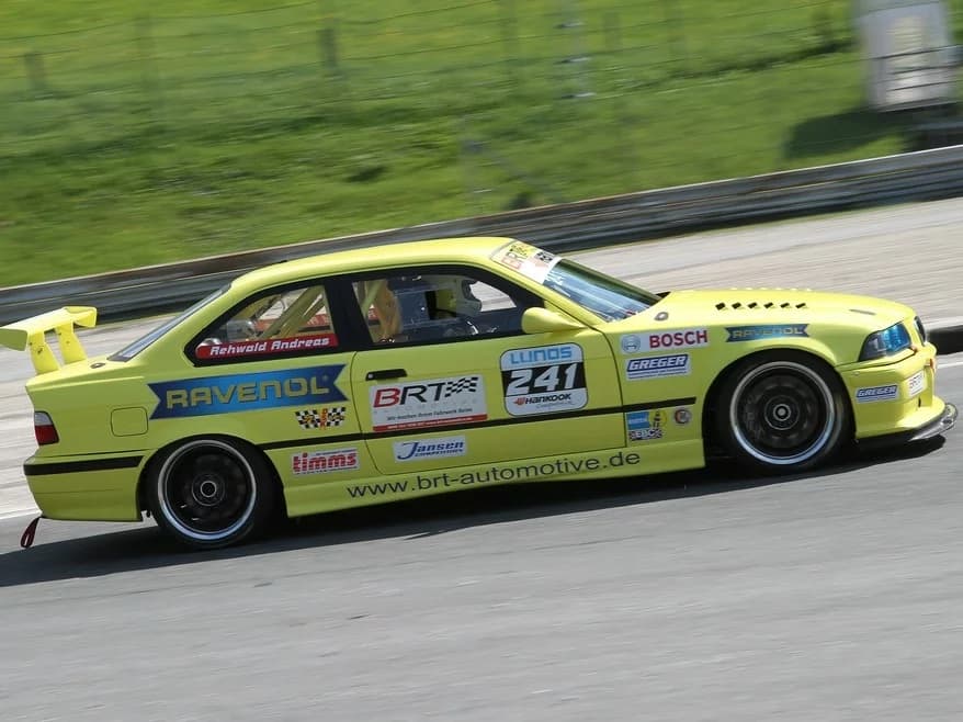 BMW E36 Coupé Seitenansicht im Motorsport-Einsatz mit Carbon-Frontlippe montiert