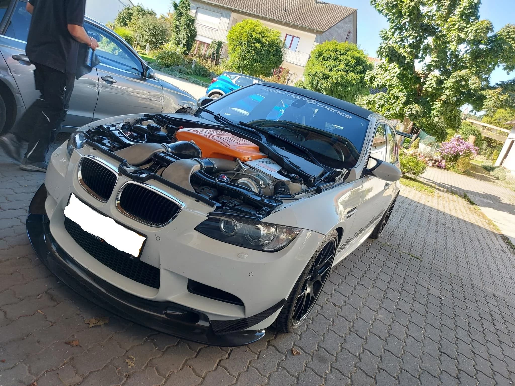 BMW E92 mit offenem Motorraum und Carbon-Canards an der Frontstoßstange, Außenaufnahme