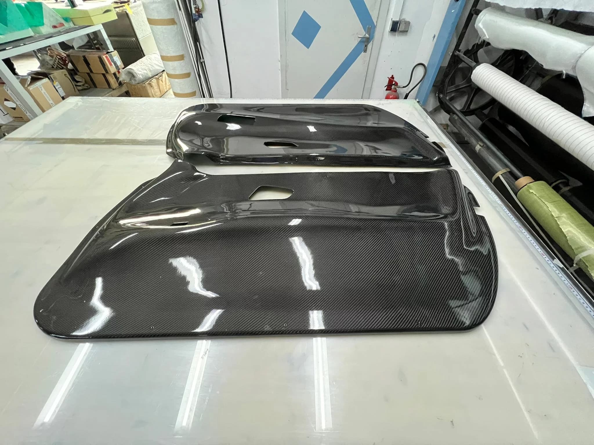 Paar Sichtcarbon Türinnenverkleidungen für BMW E92, symmetrisch ausgelegt auf Tisch
