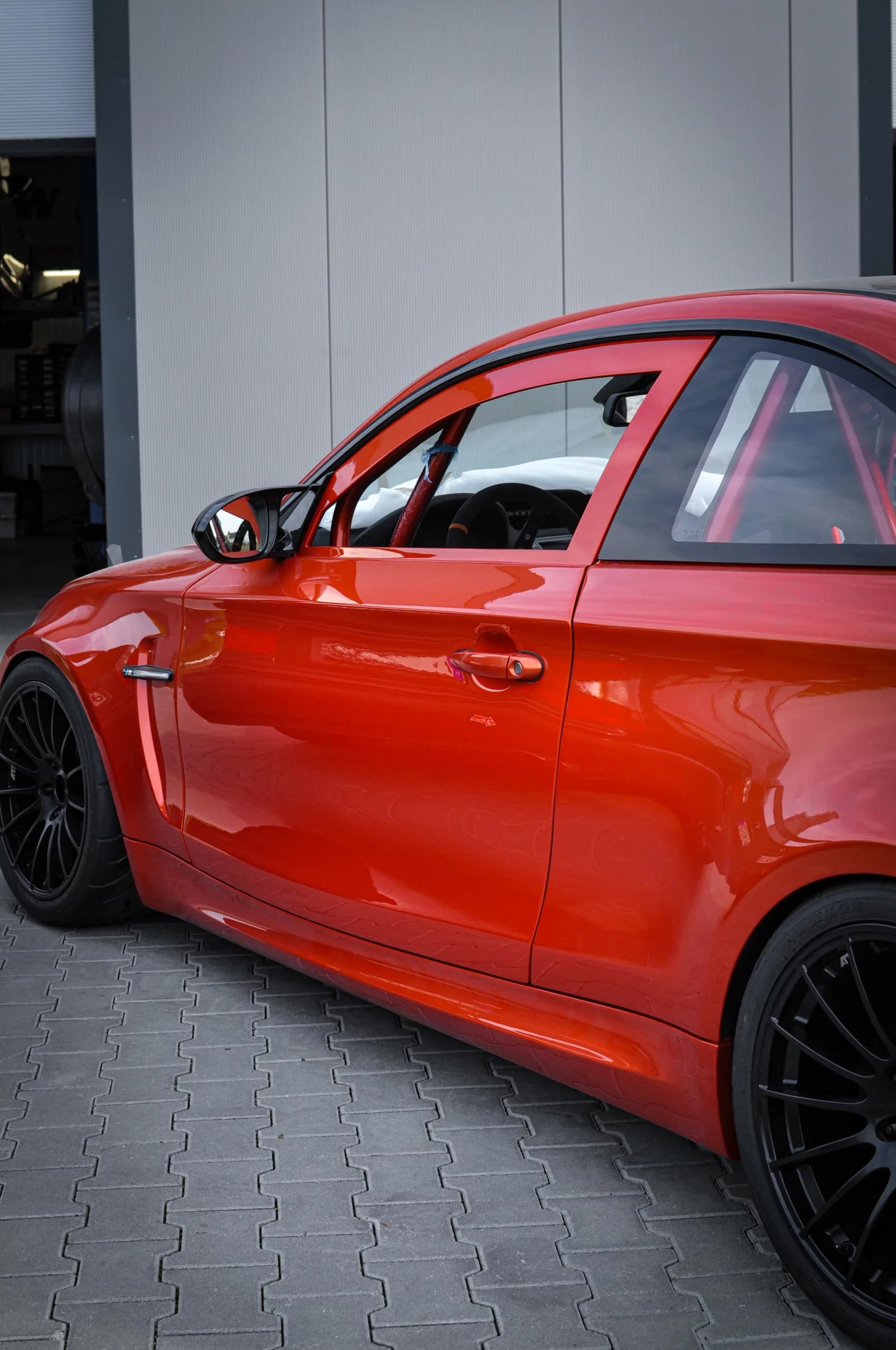 BMW E82 1er M mit Carbon-Türen, Außenansicht Fahrzeugseite in Orange