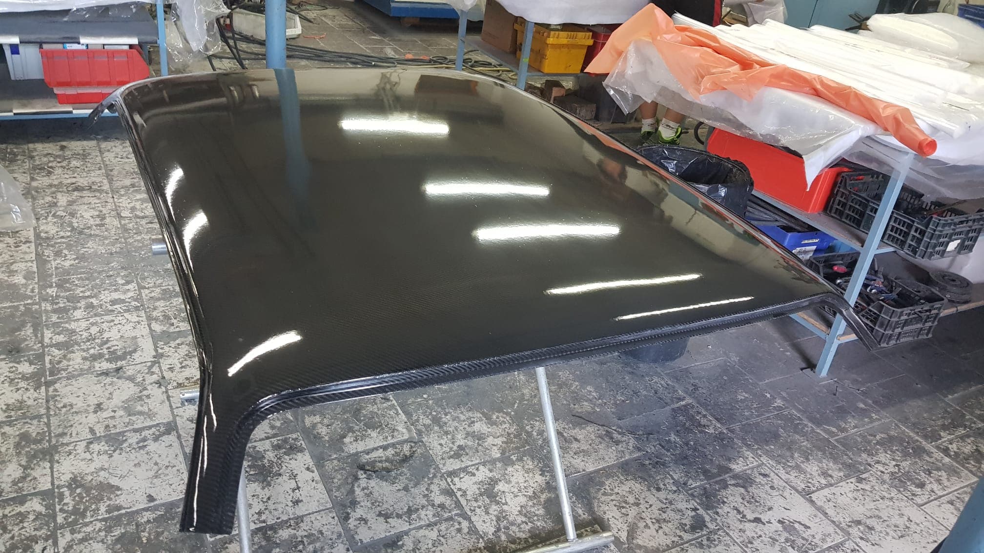 Werkstattaufnahme: Carbon-Dachhaut für BMW E30 M3 2-/4-Türer in Hochglanz, Sichtcarbon-Oberfläche mit Spiegelungen und umlaufendem Kantenprofil