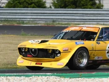 Alfa Romeo Montreal Rennfahrzeug in Gelb auf der Rennstrecke, Seitenansicht
