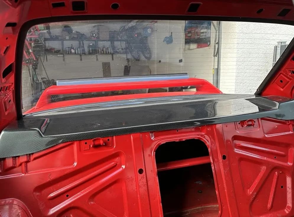 Eingebaute Carbon-Hutablage im BMW E30 M3, Ansicht aus dem Innenraum mit Blick durch die Heckscheibe