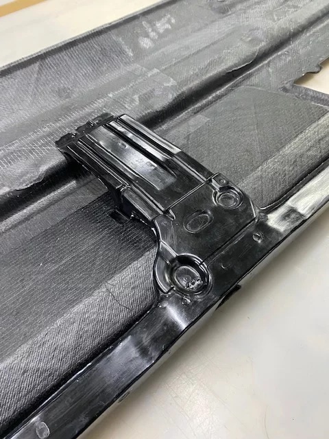 Detailaufnahme Carbon-Heckblech: verstärkte Halterung/Aufnahme im Zentrum, glänzende Oberfläche.