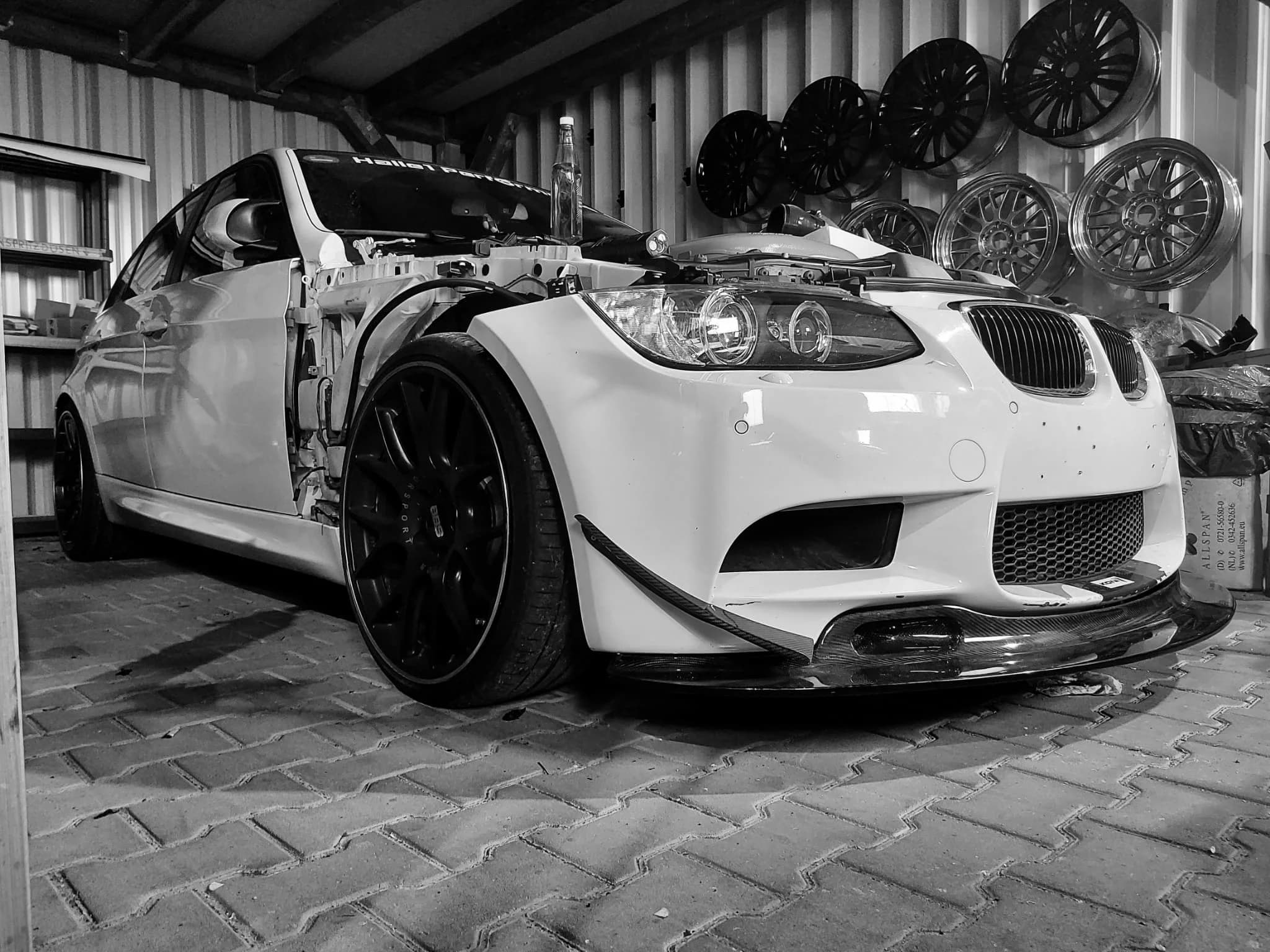 BMW E92 mit Carbon-Frontsplitter und Canards in der Werkstatt, Frontansicht in Schwarzweiß