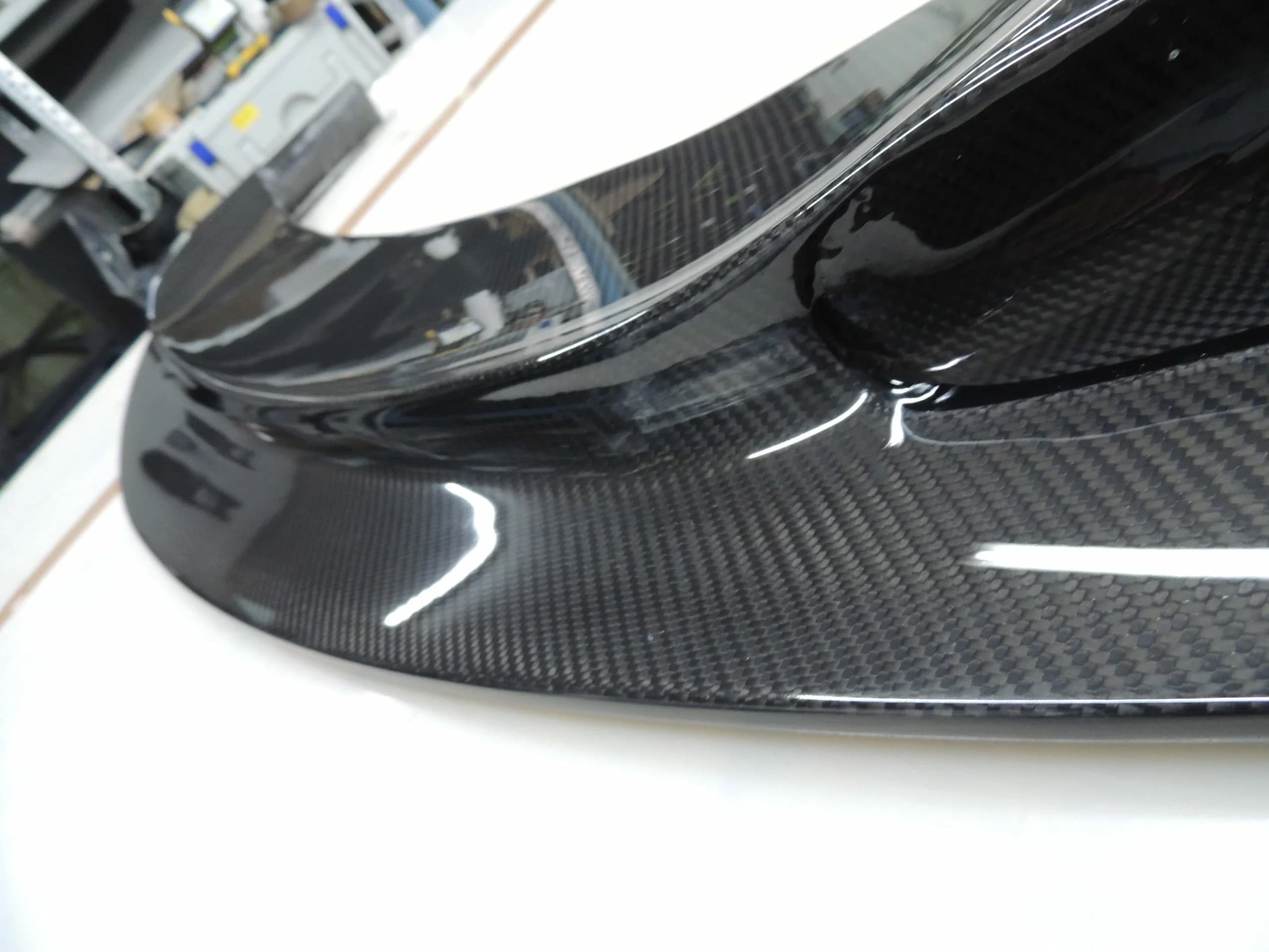 Detail der Sichtcarbon-Frontlippe am Stoßfänger des BMW E82 1er M