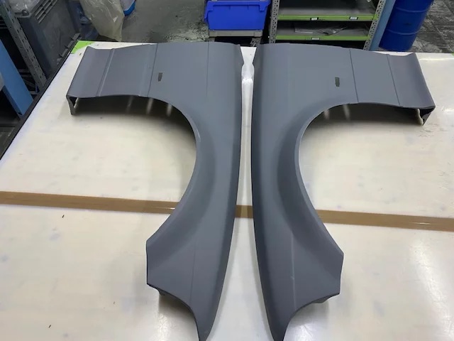 Carbon Kotflügel Set BMW E36 Coupé, breit, links und rechts, grundiert, Draufsicht auf Werkbank