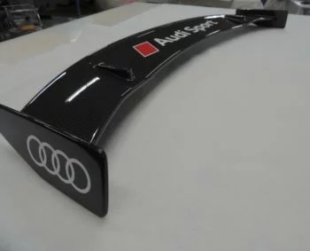 Carbon Performance Heckspoiler Audi TTRS 8S, unmontiert auf Werkbank mit Audi Ringen an der Endplatte