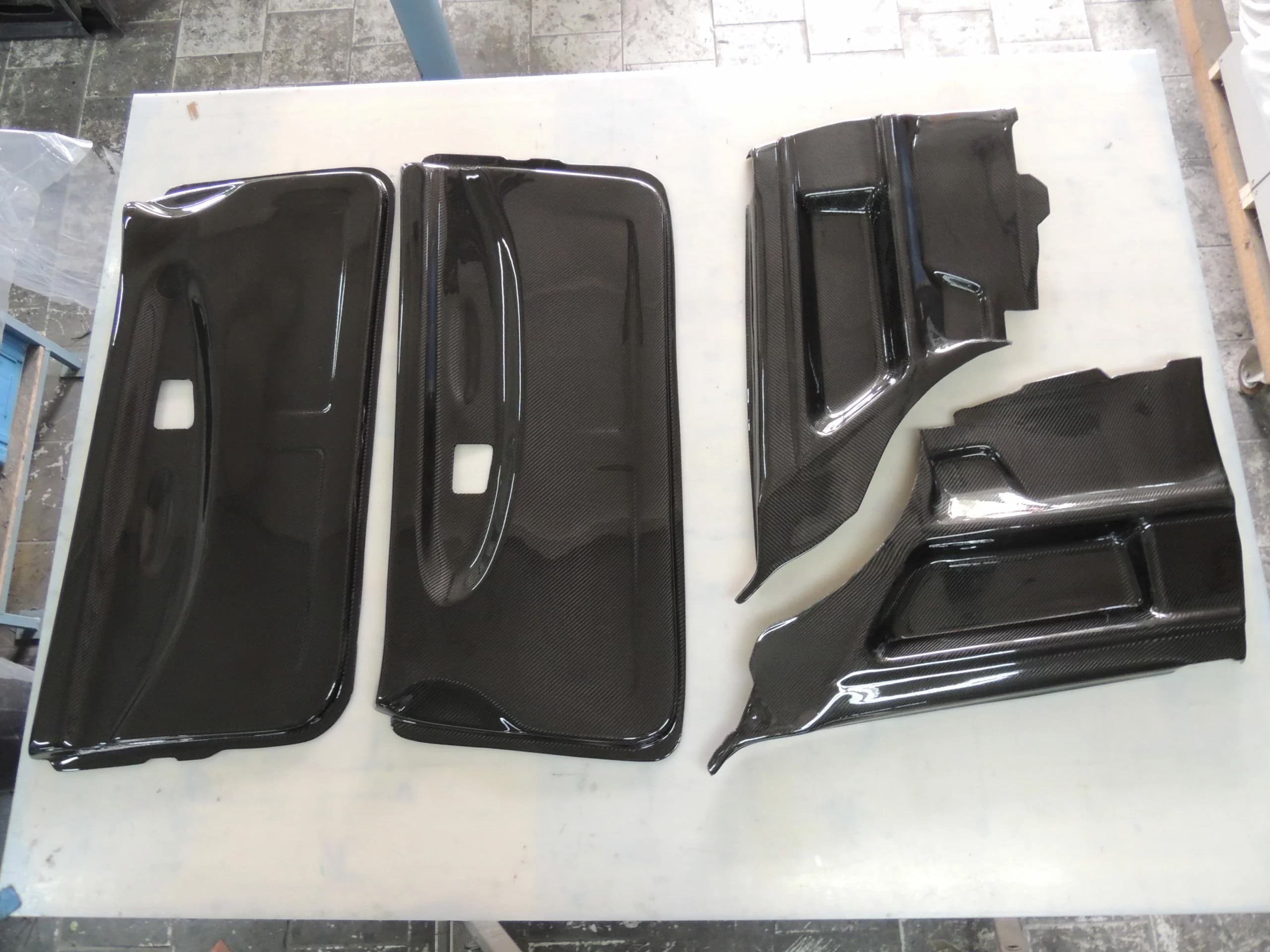Carbon Türverkleidungen Set für BMW E36 Coupé, Vorder- und Hinterteile roh auf Werkbank ausgelegt