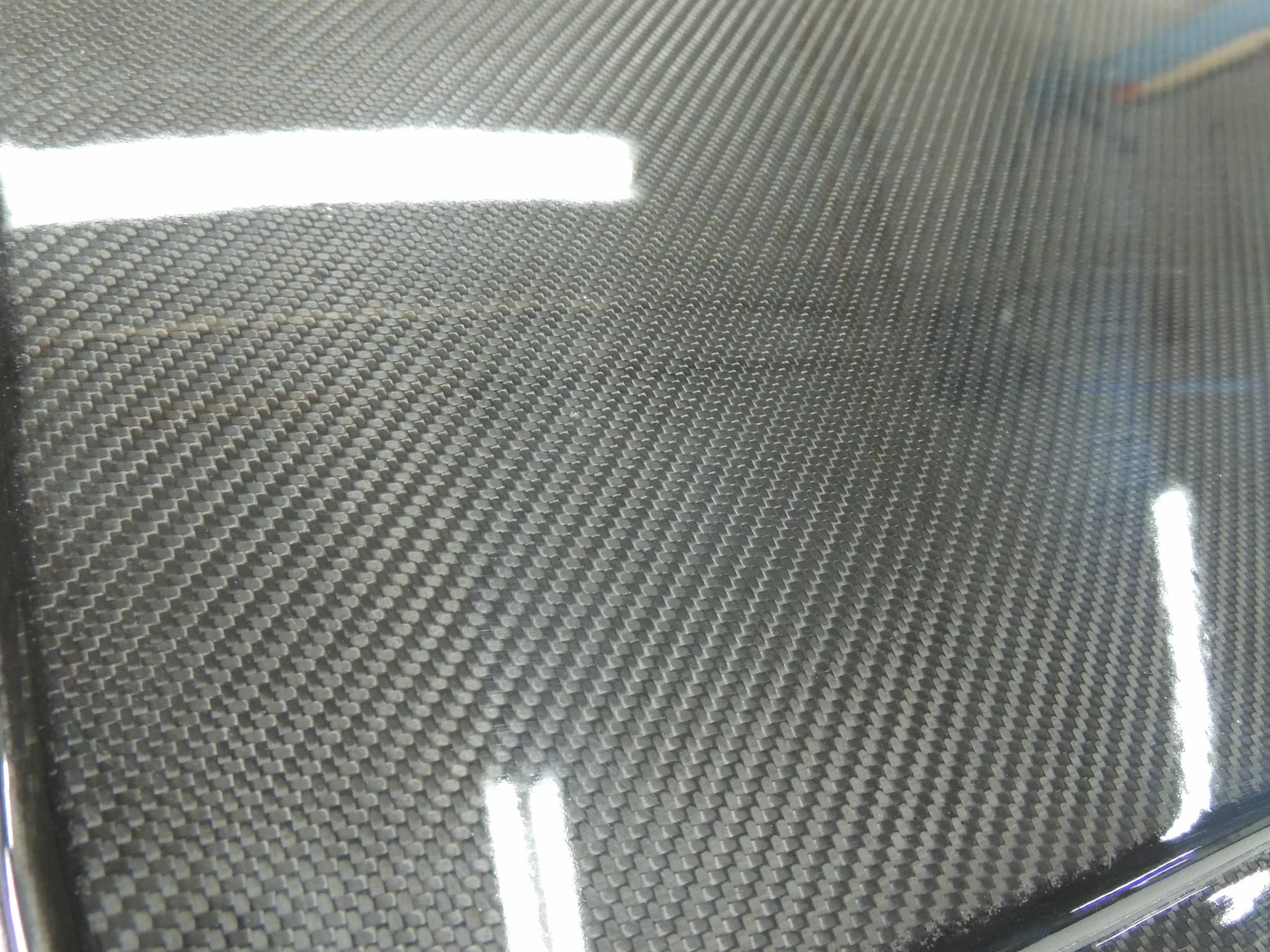 Detailaufnahme der Carbonoberfläche mit feinem Gewebe und glänzendem Klarlackfinish.