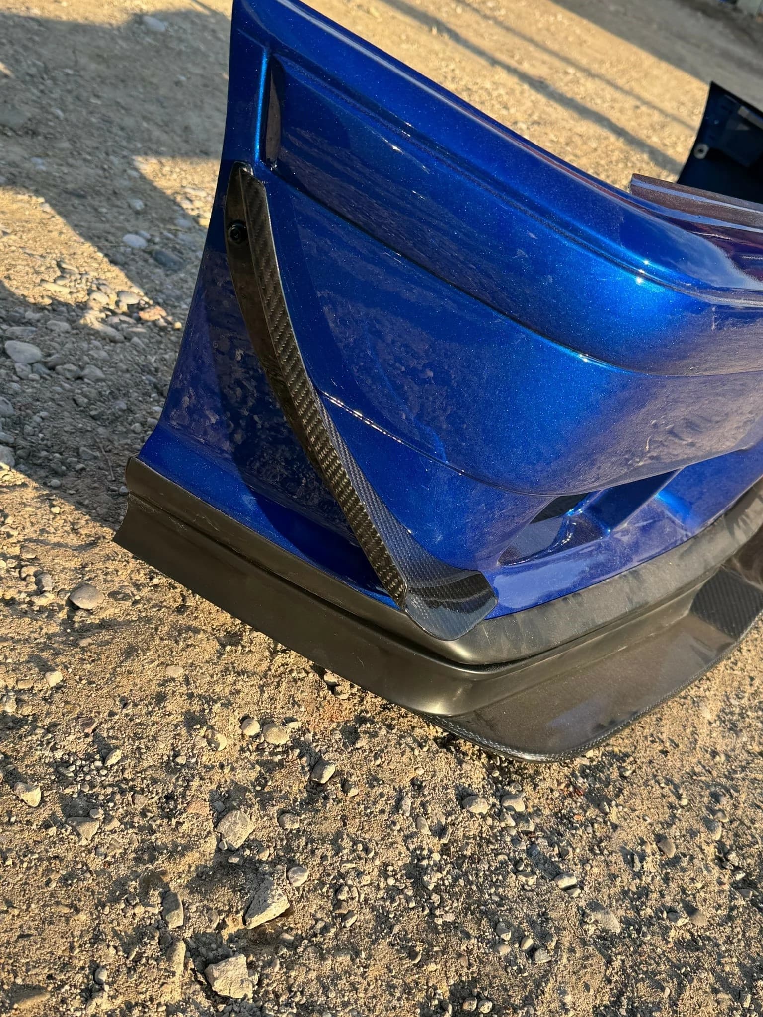 Detailansicht montiertes Carbon-Canard an blauer Frontstoßstange
