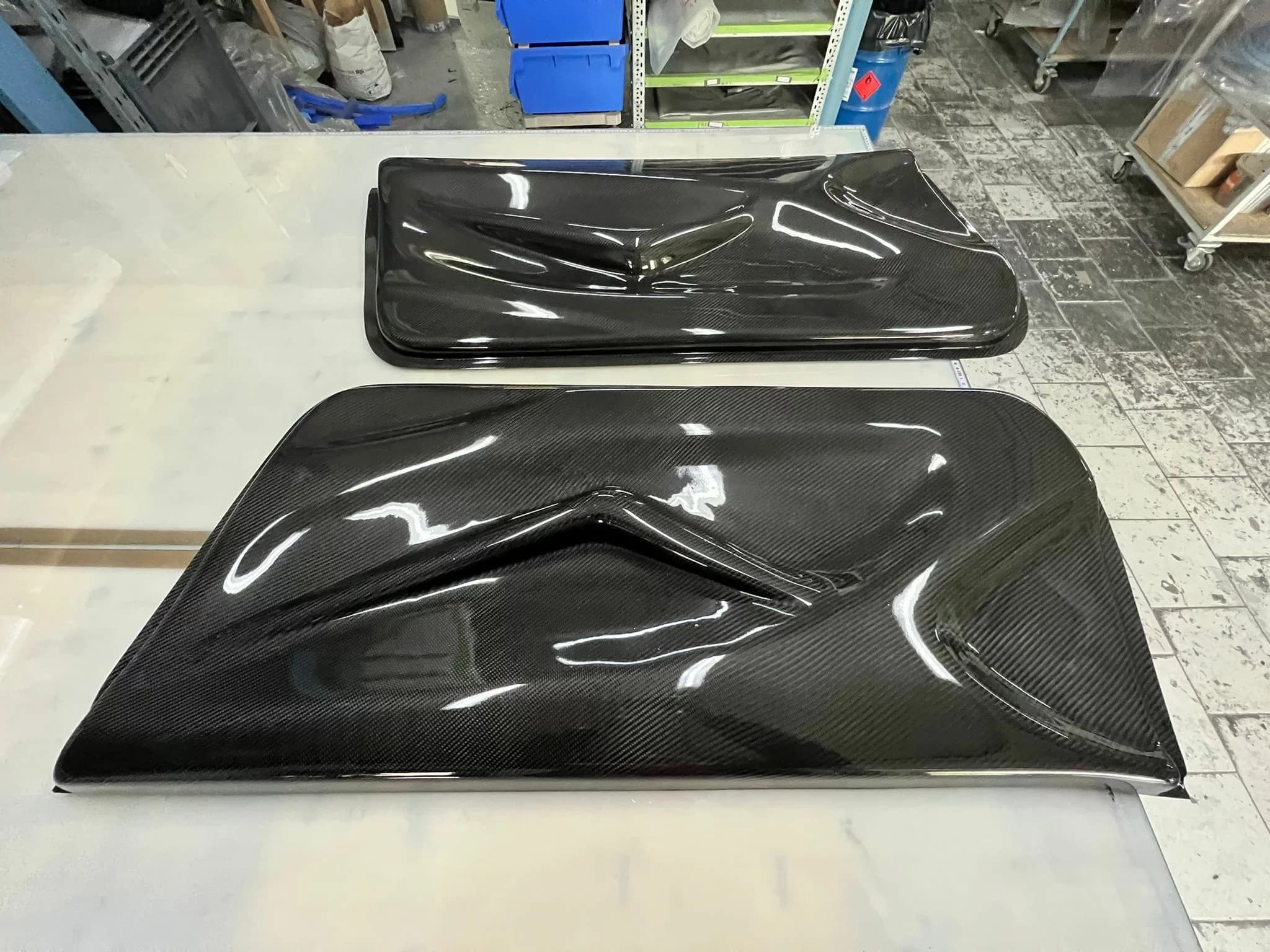 Sichtcarbon-Türverkleidung für BMW E46 M3/CSL, hochglänzend, mit ausgeprägter Linienführung, auf Arbeitstisch in der Werkstatt.