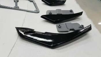 Detailansicht eines schwarzen VFL Canards mit passender grauer Halterung auf Werkbank