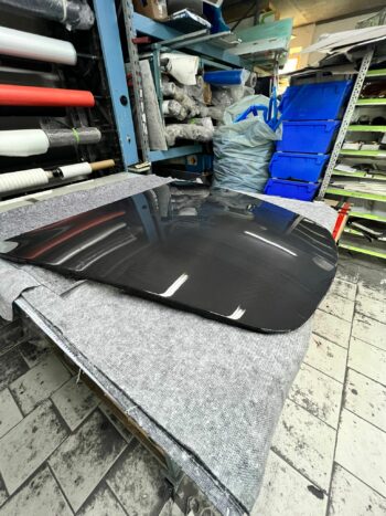 Sichtcarbon Fronthaube Porsche 911 (997), schräge Ansicht der Oberseite auf gepolsterter Arbeitsfläche