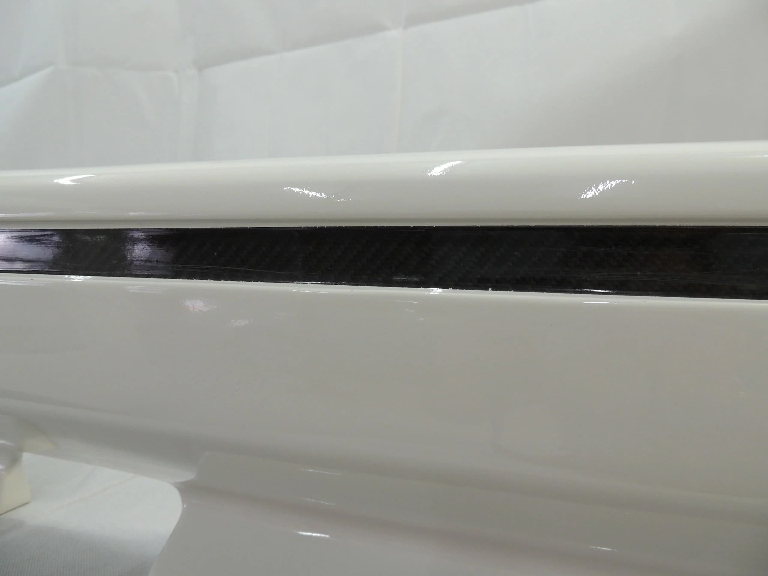 Detailaufnahme der Carbon-Zierleiste in der Heckschürze mit sichtbarer Carbonstruktur und glänzender Oberfläche.