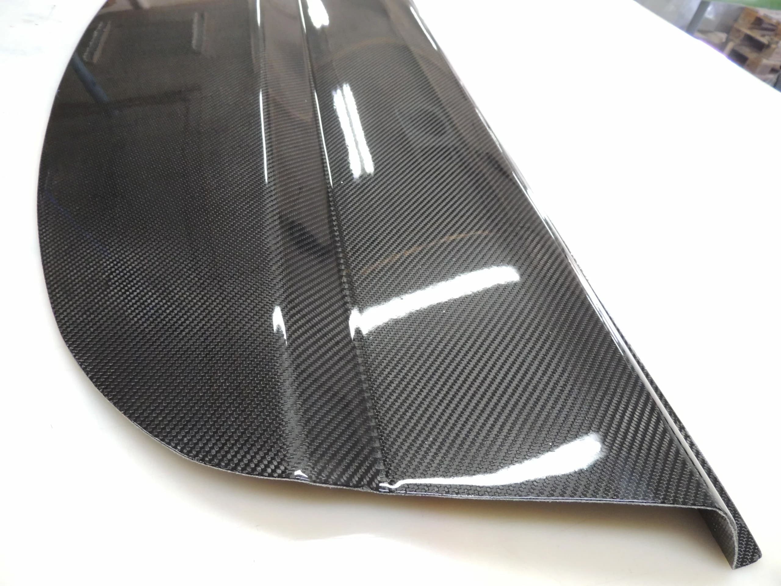 Sichtcarbon Hutablage für BMW E92, hochglänzende Carbonoberfläche mit feiner Webstruktur, Detailansicht von Kante und Wölbung.