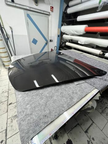 Sichtcarbon Fronthaube Porsche 911 (997), schräge Seitenansicht der unmontierten Haube auf Werkbank