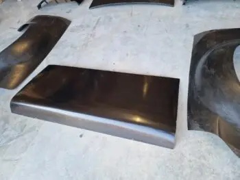Carbon Heckklappe Ford Escort MK1, einzelne Karosserieteile und Verstärkungen aus Carbon auf Werkstattboden ausgelegt